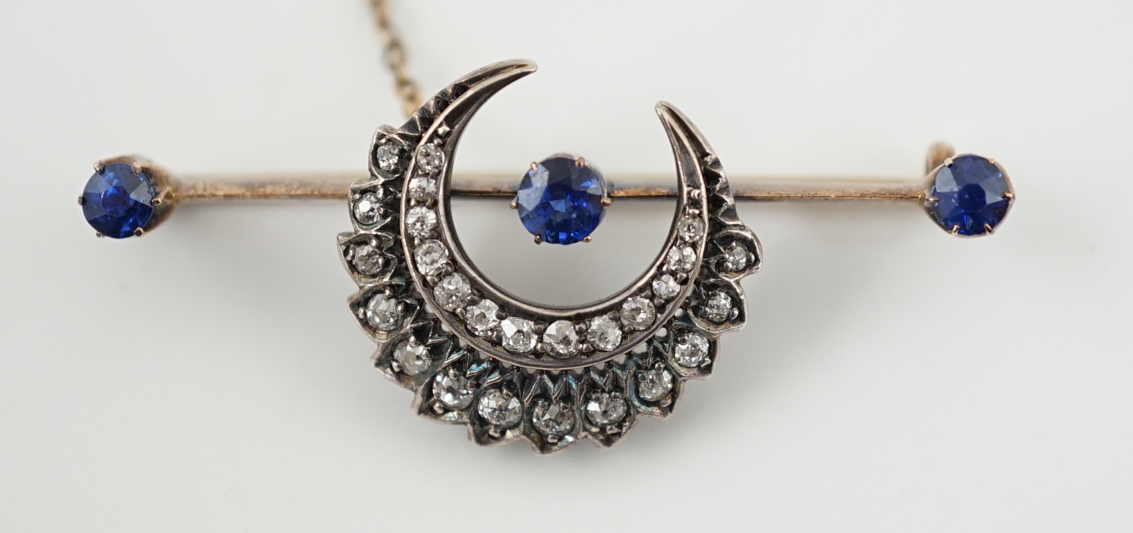 A Victorian gold and silver, three stone sapphire and diamond cluster set double crescent bar brooch
